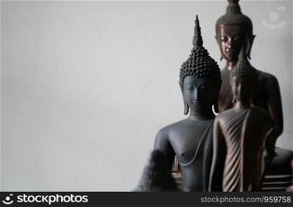 select focus of vintage black ancient buddhas statue in the middle of other buddhas statue