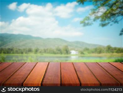 Selected focus empty brown wooden table and blue sky or mountain blur background with bokeh image. for your photomontage or product display.