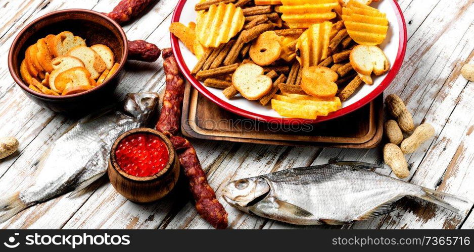 Selection of beer and snacks.Chips, fish, beer sausages on the table. Snacks for beer