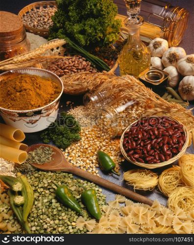 Selection of cooking ingredients including legume, pulces, spices, pasta and olive oil.