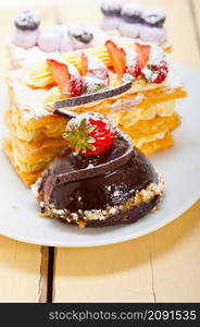 selection of fresh cream napoleon and chocolate mousse cake dessert plate