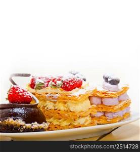 selection of fresh cream napoleon and chocolate mousse cake dessert plate