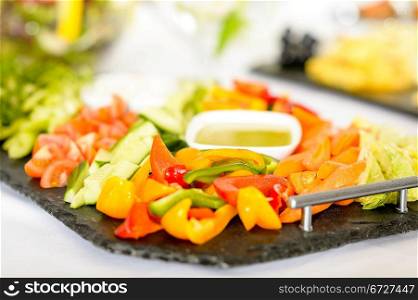 Selection of fresh vegetables with dips on serving tray