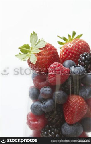 Selection Of Summer Fruits In Glass Against White Background