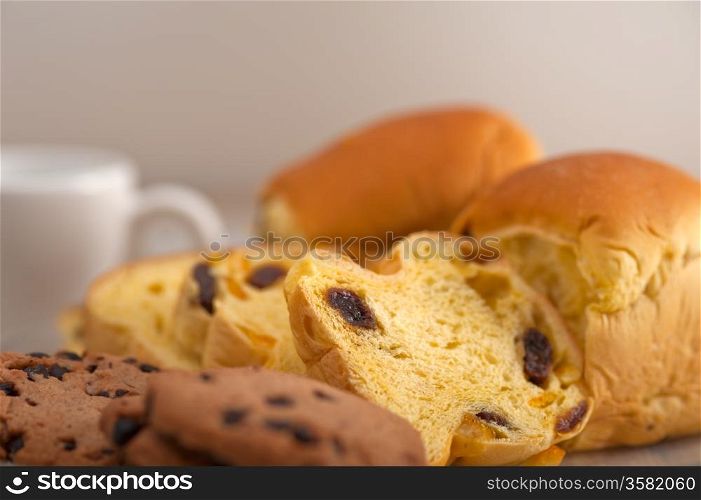 selection of sweet bread and cookies for breakfast with empty coffee cup on side