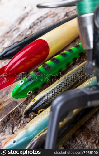selectiv focus top closeup fishing bait wobbler and reel with line on birch wooden background