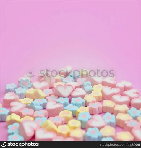 Selective focus a group of pastel sweet colorful candy marshmallows on pink background with copy space for square web banner, brochure, leaflet, flyer, advertisement template or recipe menu design