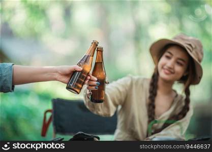 Selective focus and close up Hands of woman and friends elaxing at front of camping tent, They enjoy to cheering and drinking beer with fun and happy together