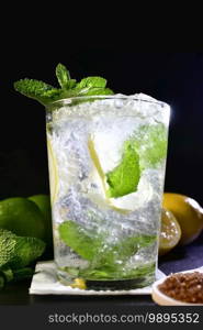 Selective focus and close up of a refreshing mojito cocktail on a napkin on a dark background. Alcohol and lifestyle concept.. close up of a refreshing mojito cocktail on a napkin on a dark background. lifestyle concept.