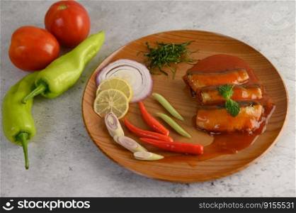 selective focus canned sardine with tomato sauce and cooking ingredient was beautiful arrangement in wooden tray, blurred chili and tomato, copy space