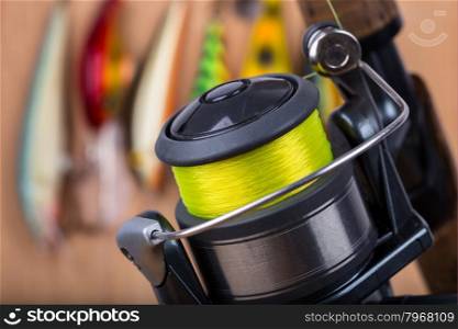 selective focus closeup fishing bait wobbler and reel with line on wooden background