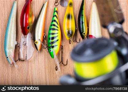 selective focus closeup fishing bait wobbler and reel with line on wooden background