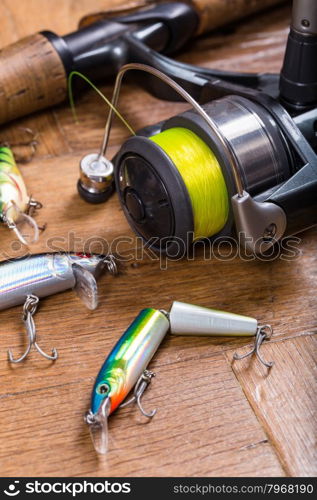 selective focus closeup fishing bait wobbler and reel with line on wooden background