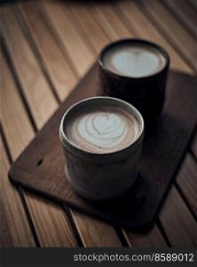 Selective focus cup of hot latte art coffee on wooden table,focus at white foam
. cup of hot latte art coffee on wooden 