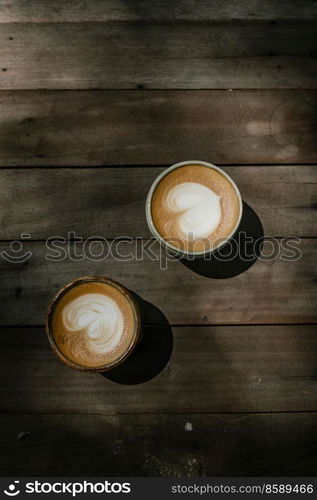 Selective focus cup of hot latte art coffee on wooden table,focus at white foam
. cup of hot latte art coffee