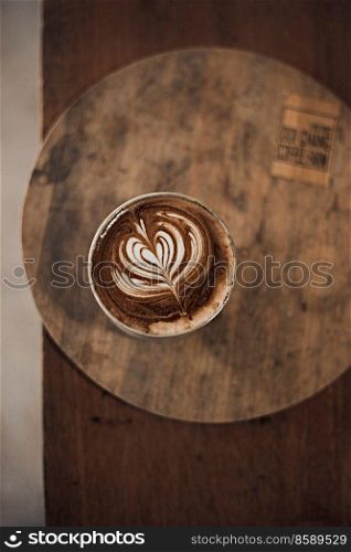 Selective focus cup of hot latte art coffee on wooden table,focus at white foam .  hot latte art coffee on wooden 