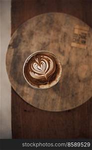Selective focus cup of hot latte art coffee on wooden table,focus at white foam .  hot latte art coffee on wooden 