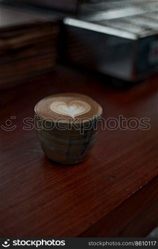 Selective focus cup of hot latte art coffee on wooden table,focus at white foam
. hot latte art coffee
