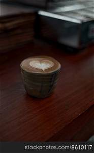 Selective focus cup of hot latte art coffee on wooden table,focus at white foam
. hot latte art coffee