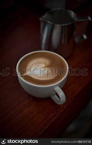 Selective focus cup of hot latte art coffee on wooden table,focus at white foam . hot latte art coffee
