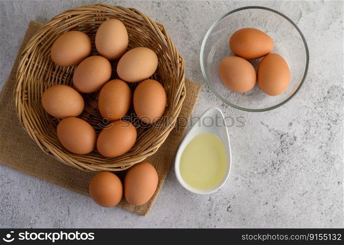 Selective focus eggs on sack cloth, many eggs on wicker basket and glasses bowl, the egg whisk placed on the floor, preparing for cooking food or dessert, copy space
