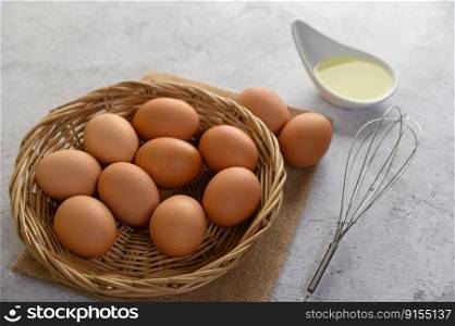 Selective focus eggs on sack cloth, many eggs on wicker basket and glasses bowl, oil and egg whisk placed on the floor, preparing for cooking food or dessert, copy  space