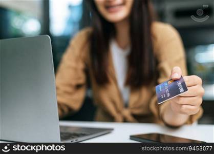 Selective focus,  Female hand holding credit card, Young woman shopping online and payment with credit card, smartphone on table
