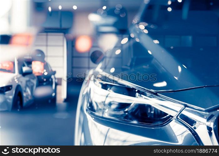 Selective focus grey car parked in luxury showroom. Car dealership office. New car parked in modern showroom. Car for sale and rent business concept. Automobile leasing and insurance background.