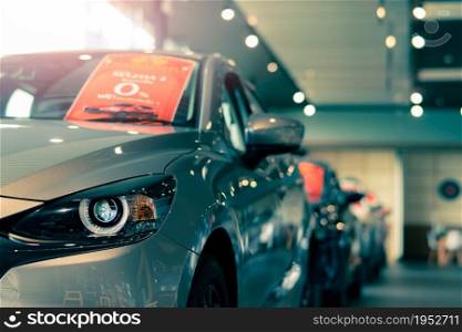 Selective focus grey car parked in luxury showroom. Car dealership office. New car parked in modern showroom. Car for sale and rent business concept. Automobile leasing and insurance background.