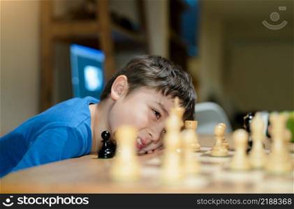 Selective focus Happy Young boy developing chess strategy, playing board game with parent at home. Activity or Hobby for Family Concept