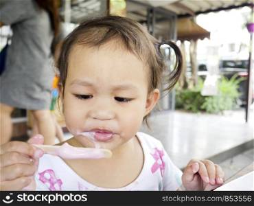 Selective focus little Asian girls is happy to eat a delicious ice cream, copy space.