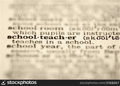 Selective focus of dictionary definition for the word schoolteacher.