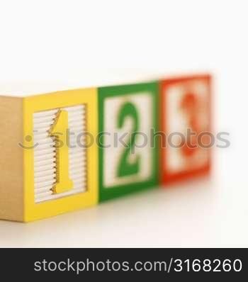 Selective focus of fow of toy building blocks with numbers.