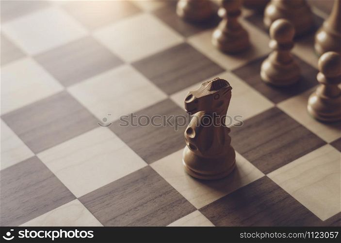 Selective focus of wood knight chess on board game with blurry background, Business leader and confrontation solve problems concept, Chess horse on board with copy space