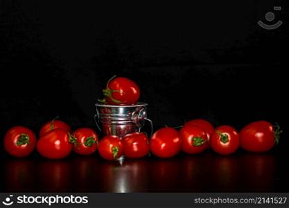 Selective focus on composition with mini decorative bucket and tomatoes. Small metal bucket with cherry tomatoes