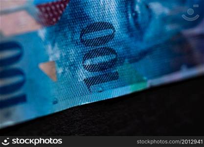 Selective focus on detail of 100 swiss franc banknote. Close up macro detail of money banknotes, swiss franc isolated. World money concept, inflation and economy concept