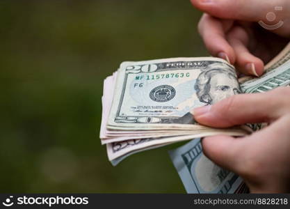 Selective focus on detail of USD banknotes. Counting or giving United States Dollars banknotes. World money concept, inflation and economy concept