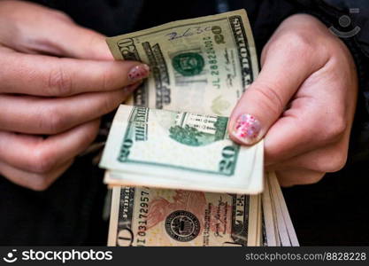 Selective focus on detail of USD banknotes. Counting or giving United States Dollars banknotes. World money concept, inflation and economy concept