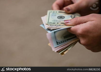 Selective focus on detail of USD banknotes. Counting or giving United States Dollars banknotes. World money concept, inflation and economy concept