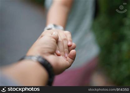 selective focus on hands of couple.Walking hand of traveler travel nature Forests.Woman holding boyfriend?s hand traveling in garden park