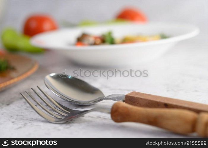 Selective focus spoon with fork , blurred sardine in tomato sauce and spicy sardine on white table, copy space