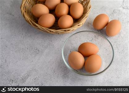 Selective focus three eggs in glasses bowl, blurred eggs in wicker basket an on the floor, preparing preparing for cooking food or dessert, copy space 