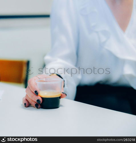 Selective focus view of corporate woman holding a plastic coffee cup.. Selective focus view of corporate woman holding a plastic coffee cup