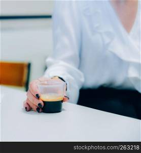 Selective focus view of corporate woman holding a plastic coffee cup.. Selective focus view of corporate woman holding a plastic coffee cup