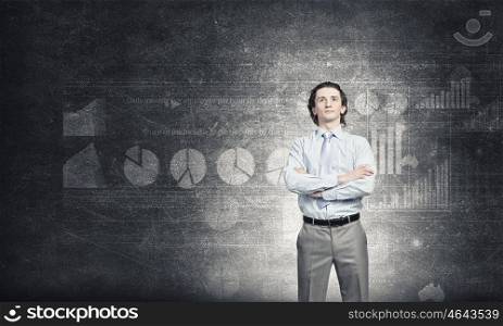 Self assured businessman . Confident businessman standing with arms crossed on chest on background of concrete wall