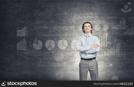 Self assured businessman . Confident businessman standing with arms crossed on chest on background of concrete wall