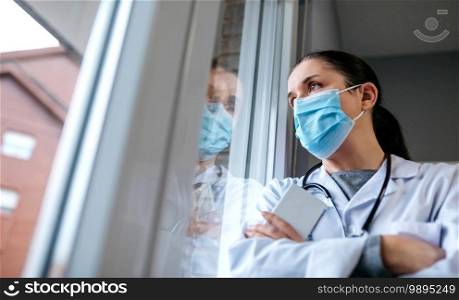 Self confident female doctor looking out the hospital window