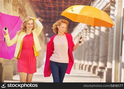 Self-confident girls walking with colorful umbrellas
