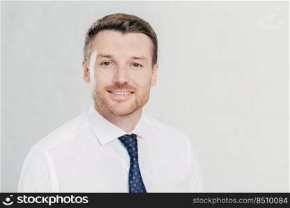 Self confident handsome unshaven male employee, wears white shirt and tie, rejoices signing agreement between business partners, isolated over white background. Confident man director indoor