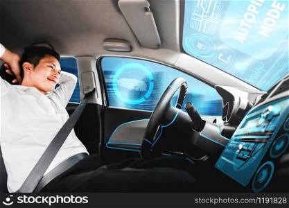 Self-driving autonomous car with relaxed young man sitting at driver seat is driving on busy highway road in the city. Concept of machine learning, artificial intelligence and augmented reality.. Self-drive autonomous car with man at driver seat.